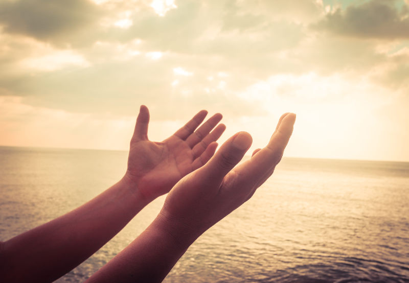 A man praying with hands together for blessings